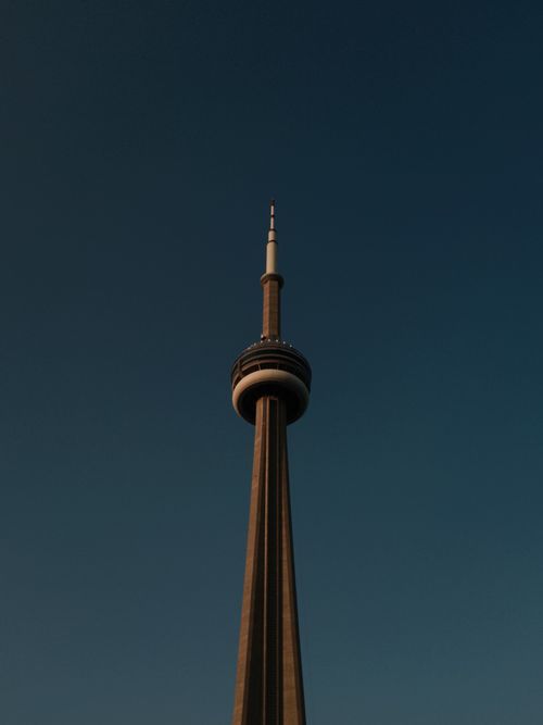 Free The CN Tower captured at twilight, silhouetted against a deep blue sky in Toronto, Canada. Stock Photo