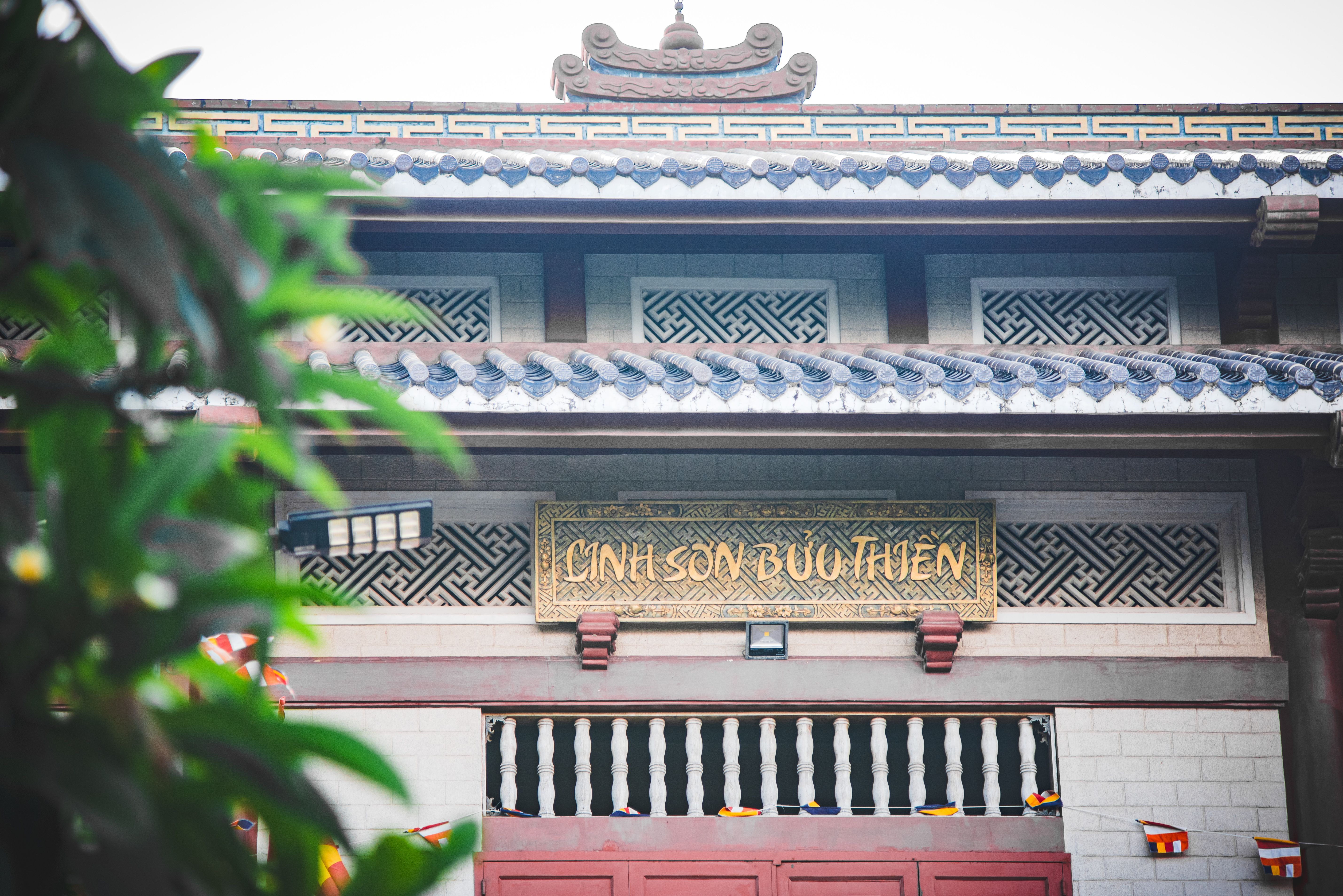 Front view of a traditional Vietnamese pagoda entrance featuring intricate architecture and cultural signage.