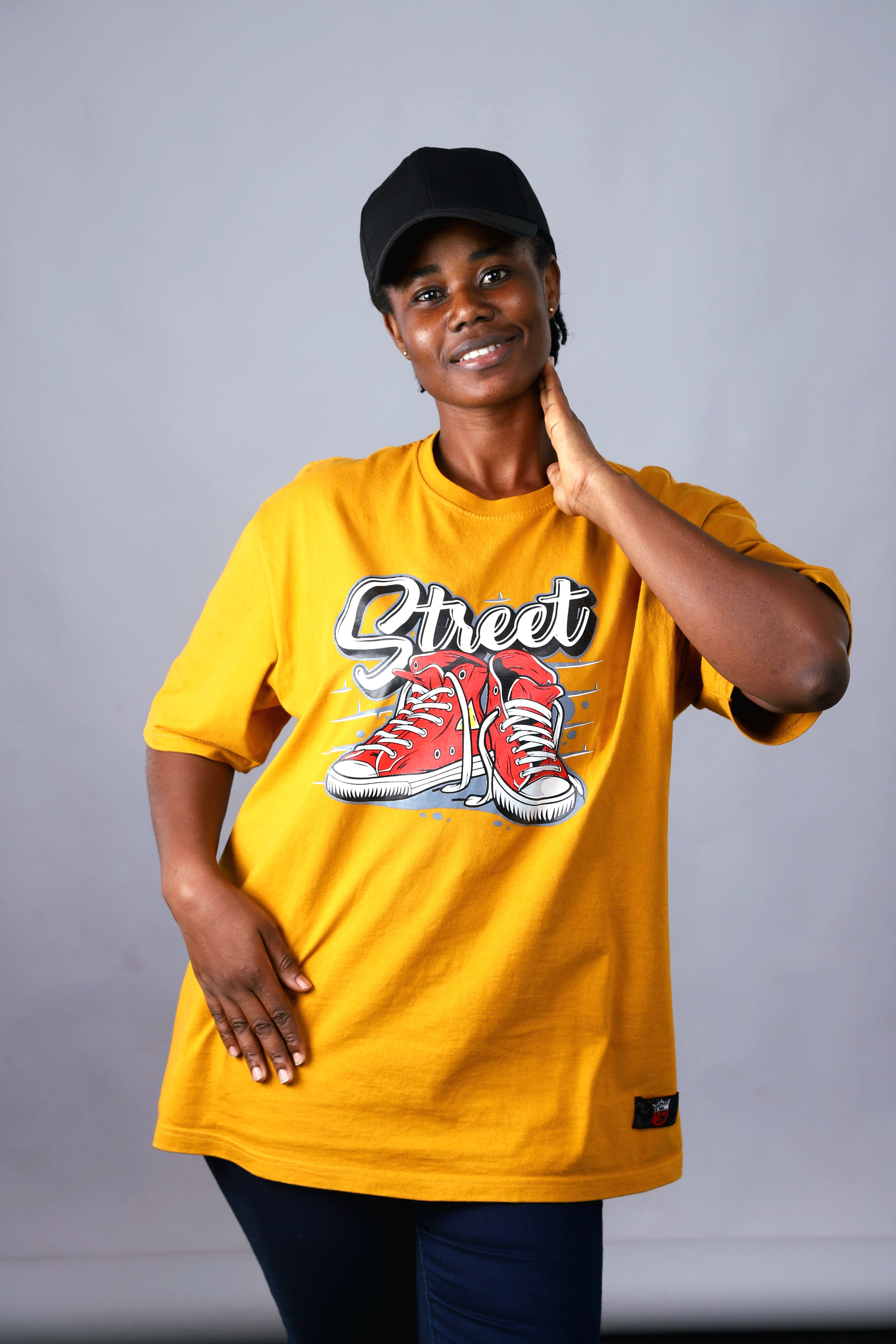 Portrait of a woman in a yellow streetwear t-shirt indoors.