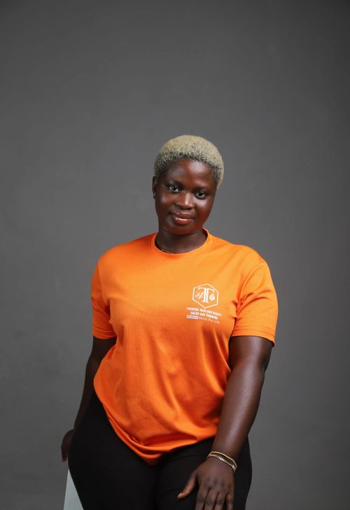 Free Portrait of a confident woman in an orange shirt against a gray background. Stock Photo