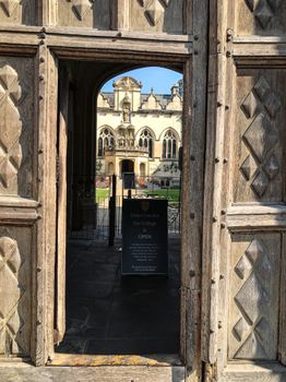 View of ornate architecture from a wooden doorway at an Oxford college.