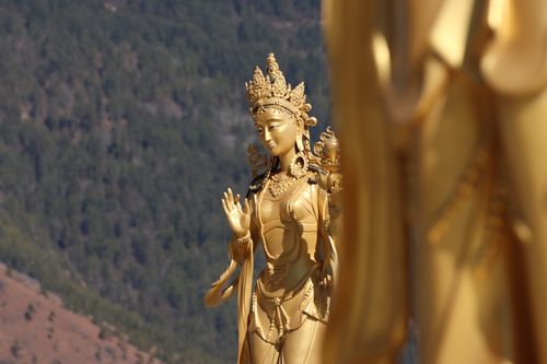 Free A captivating shot of a golden Buddhist statue with a mountainous backdrop, radiating tranquility. Stock Photo