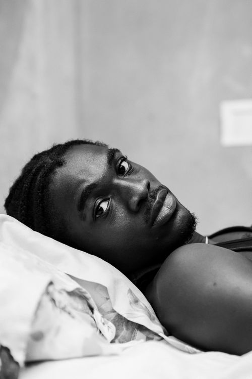 Free Black and white portrait of a relaxed man lying indoors, Accra, Ghana. Stock Photo