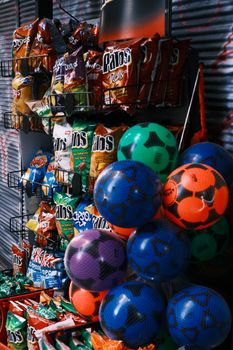 Vibrant assortment of snack foods and colorful balls in a store setting. Bold colors and diverse product selection.