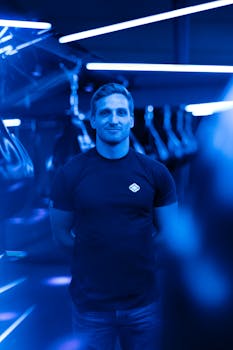 现代健身房里，充满活力的蓝色霓虹灯下，一位男性健身教练的肖像