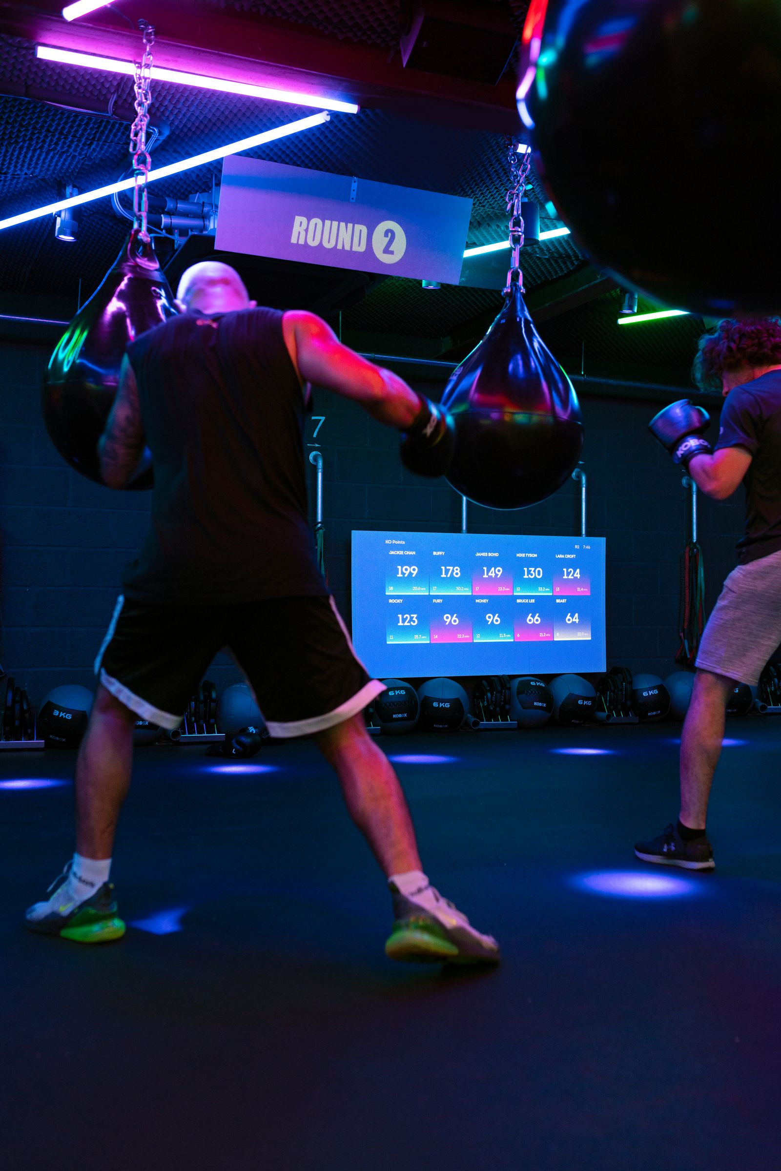 Athletes training with heavy bags in a boxing gym