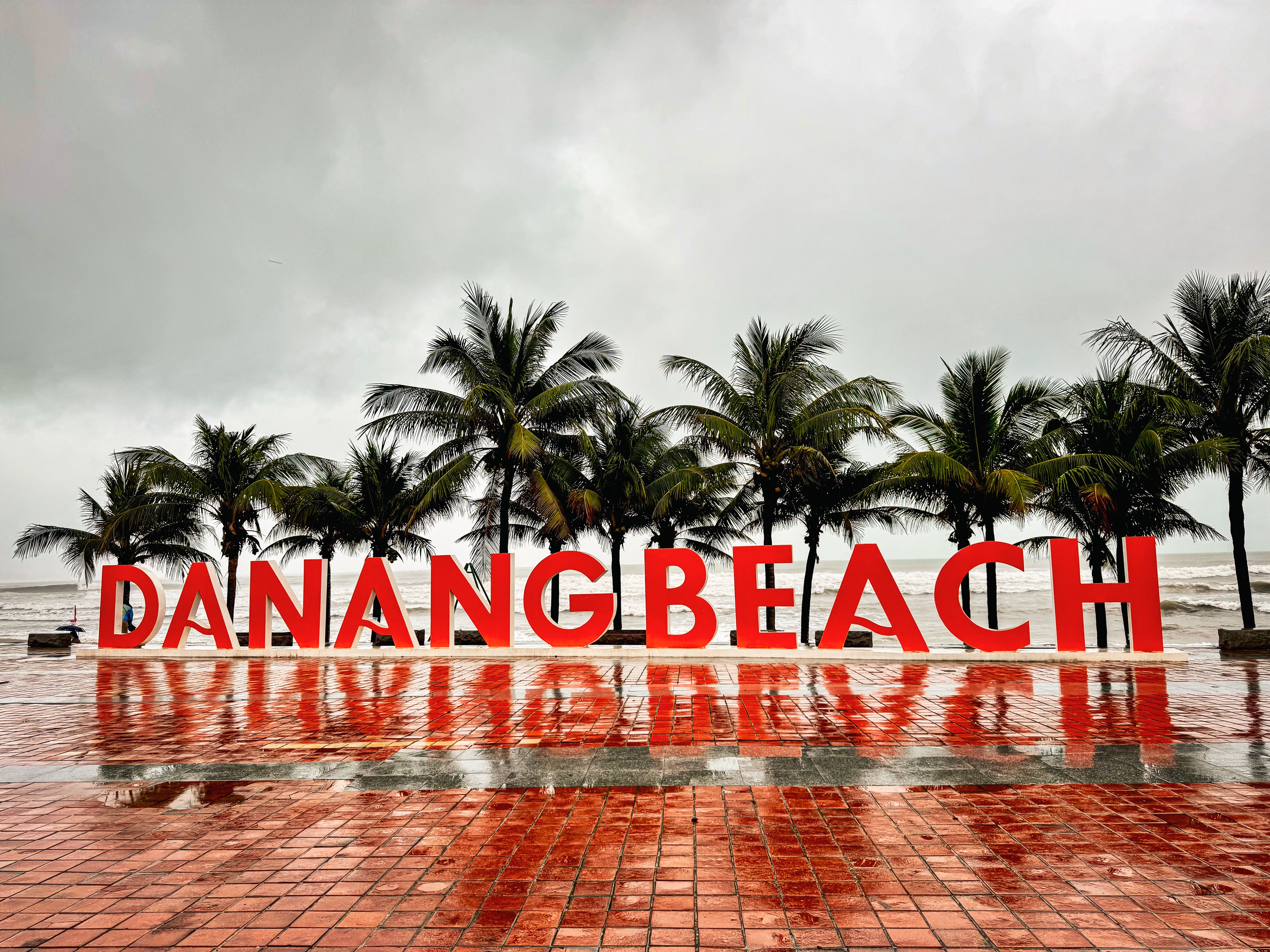 A stormy day at Danang Beach, Vietnam with palm trees and reflective wet tiles. — arriving in Da Nang