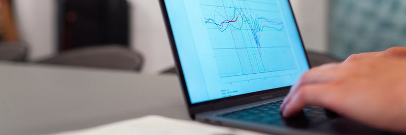 A person working on a graph analysis on a laptop for data monitoring and research.