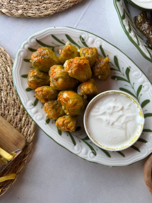 Free Delicious stuffed zucchini flowers served with a creamy dip on a decorative plate. Stock Photo