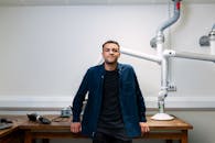 在拥有先进机器人设备的实验室里，站着一位自信的年轻工程师