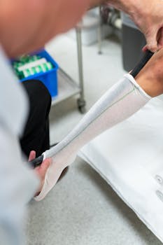 Orthotic technician measuring patient's leg for custom orthotic in a healthcare setting.