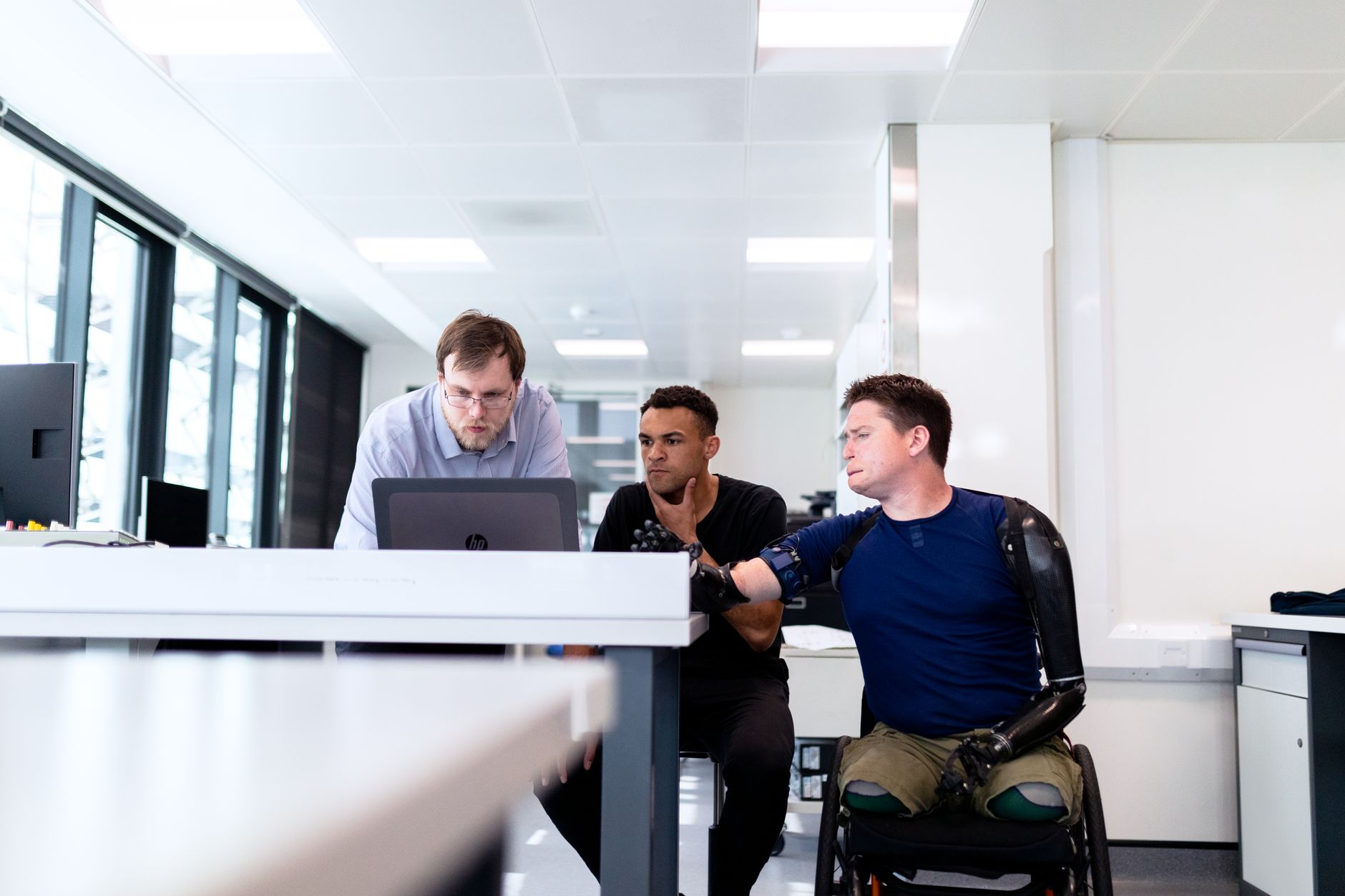 Team of engineers and designers working on prosthetic innovations in a modern office setting.