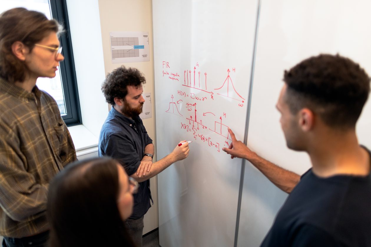 Engineers discussing data on a whiteboard