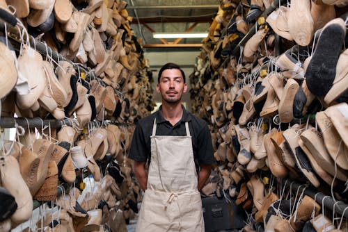 Free Man Wearing White Apron In Between Wooden Shoe Molds Stock Photo