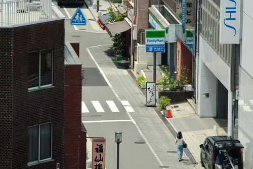 Free Top-down view of a street in Osaka, Japan with a cyclist and pedestrian. Stock Photo