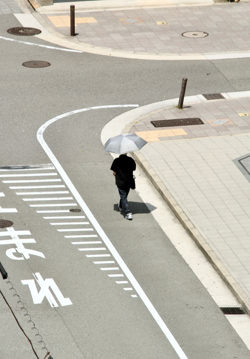 Free Aerial view of a pedestrian crossing in Osaka with a person holding an umbrella. Stock Photo