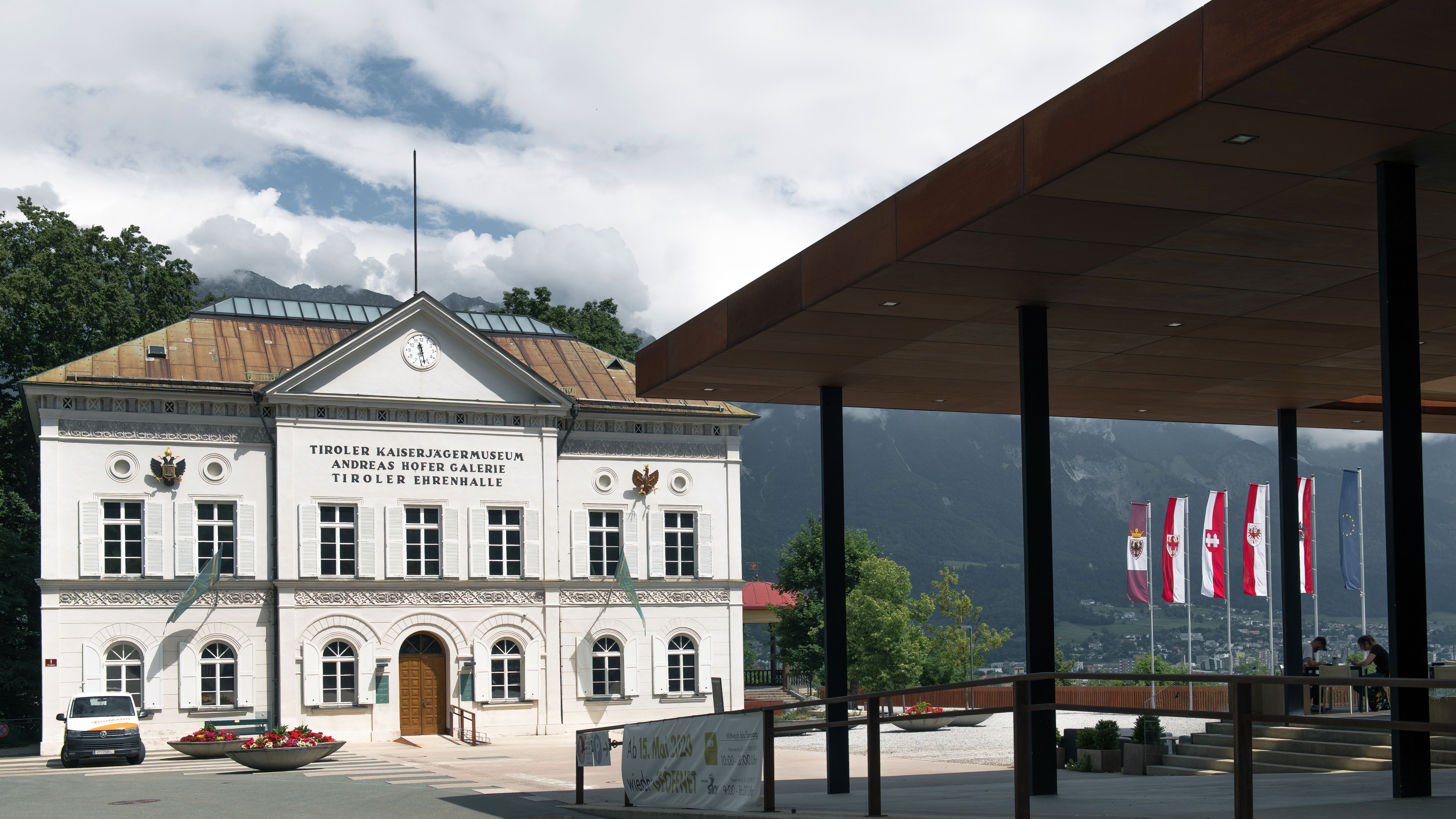 Classic view of the Tiroler Kaiserjägermuseum in Innsbruck, Austria, showcasing its historic architecture and flags.