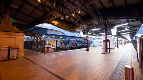 Free Wide view of Central Railway Station platform in Sydney at dusk with trains and architectural details. Stock Photo