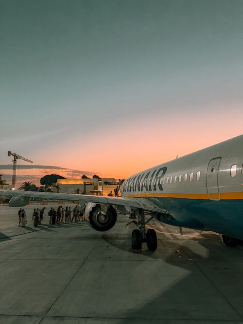 Free Passengers boarding plane at sunset in Malta, capturing vibrant skies and travel mood. Stock Photo
