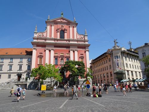 Free The beautiful Franciscan Church in Ljubljana's bustling Preseren Square on a sunny summer day. Stock Photo