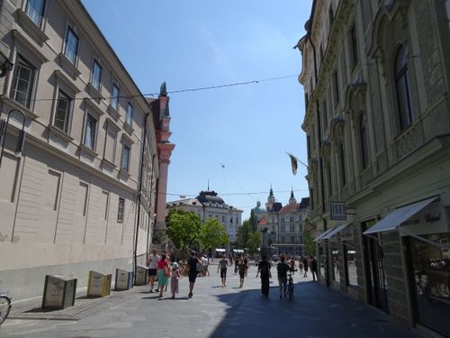Free Experience a sunny summer day in Ljubljana with people walking along historic streets. Perfect for travel exploration. Stock Photo