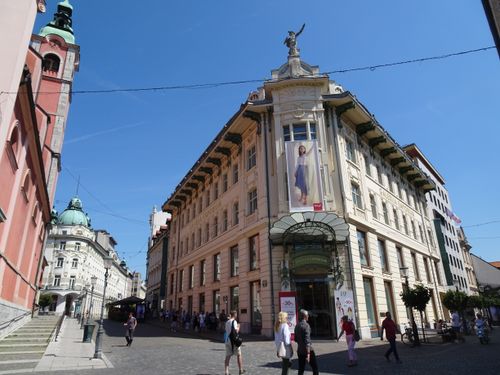 Free Sunlit view of a historic building on a bustling street in Ljubljana, Slovenia's scenic capital. Stock Photo