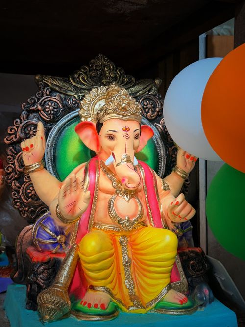 Free Colorful Lord Ganesha statue adorned with decorations and balloons, symbolizing prosperity. Stock Photo