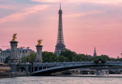 Free Scenic view of the Eiffel Tower at sunset, with Alexandre III Bridge and the Seine in Paris. Stock Photo