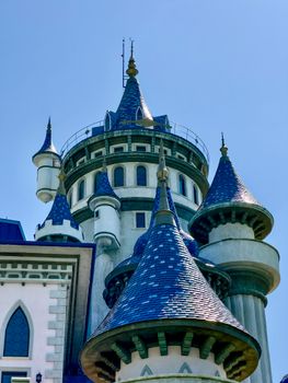 A fantasy-inspired castle tower with blue roofs set against a clear sky, evoking fairy tales.