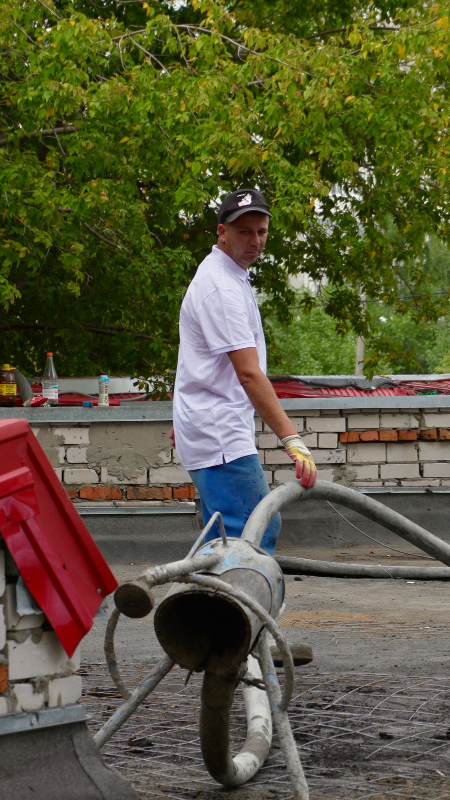 Worker operating a concrete pump delivery hose