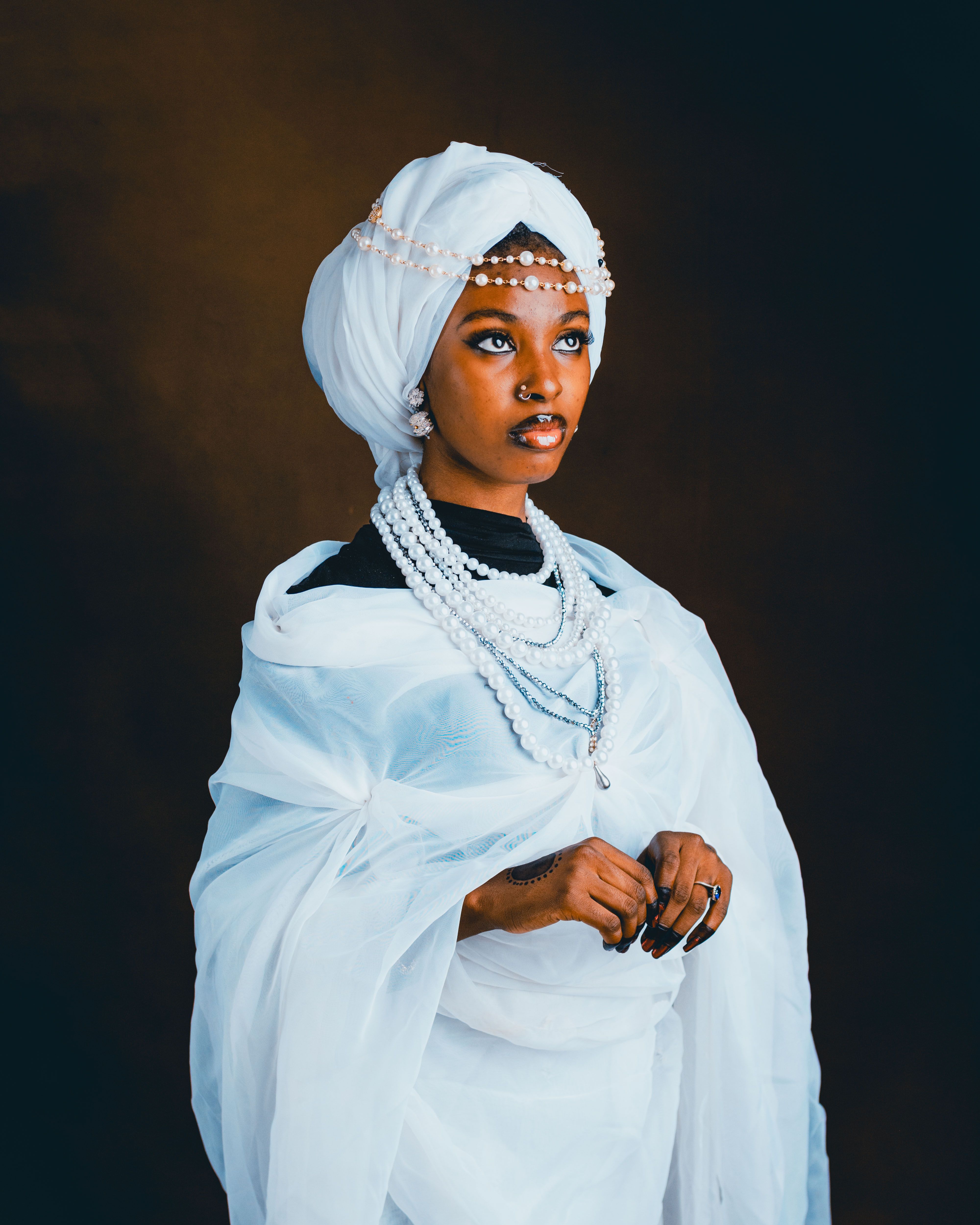 Beautiful portrait of an adult woman in traditional attire with pearl accessories, showcasing elegance and culture.