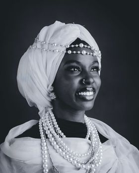 Elegant portrait of a woman in Kano, Nigeria, wearing traditional attire and jewelry. Timeless black and white style.