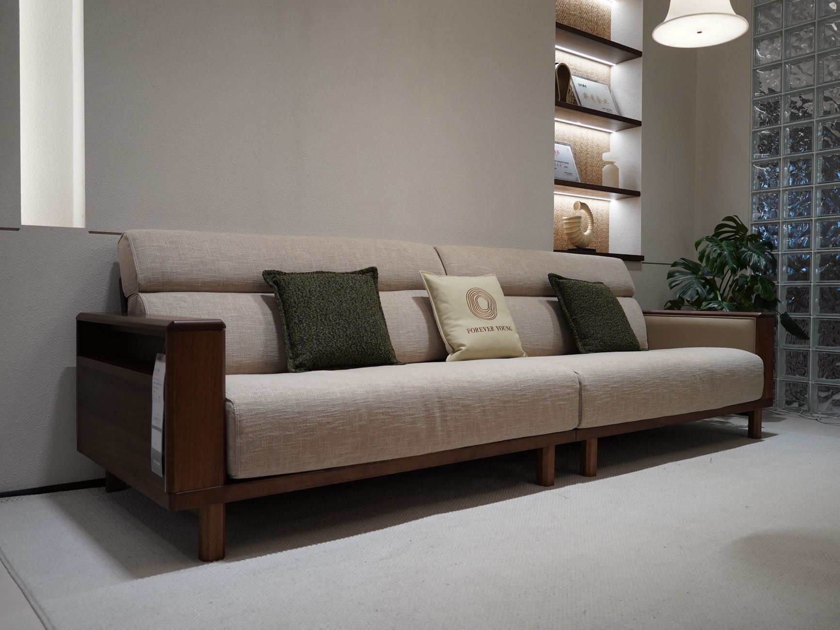 Stylish living room with a beige sofa, green cushions, modern decor, and indoor plant.