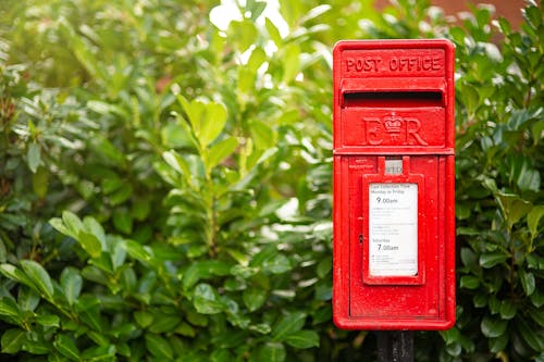 Free Red Mail Box In Front Of A Plant Stock Photo