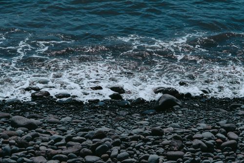 Free Serene view of ocean waves hitting a rocky beach in Valle Gran Rey, Canary Islands. Stock Photo