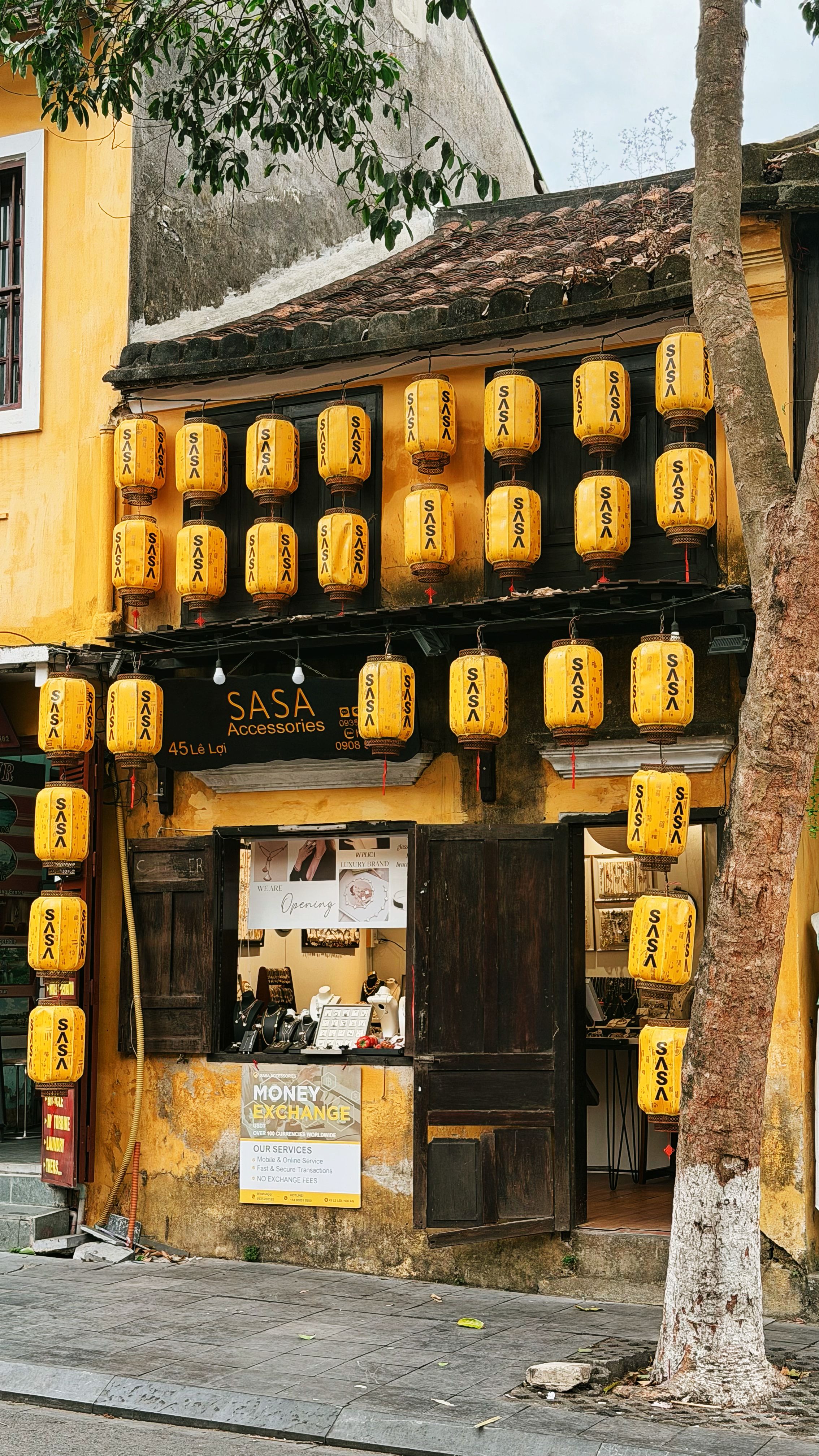 Historic Vietnamese shop adorned with traditional yellow lanterns in Hoi An, a UNESCO heritage site.