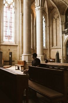 A person sitting in a serene historic cathedral, capturing a moment of reflection and peace.