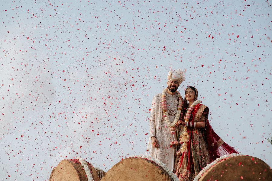 Bride and groom celebrating under a shower of rose petals