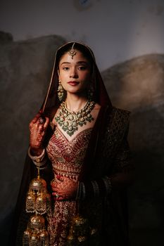 Elegant portrait of a South Asian bride in traditional attire with intricate jewelry.