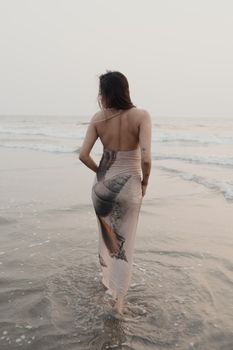 黄昏时分，一位身着优雅连衣裙的女子漫步在沙滩上。 - 相关推荐