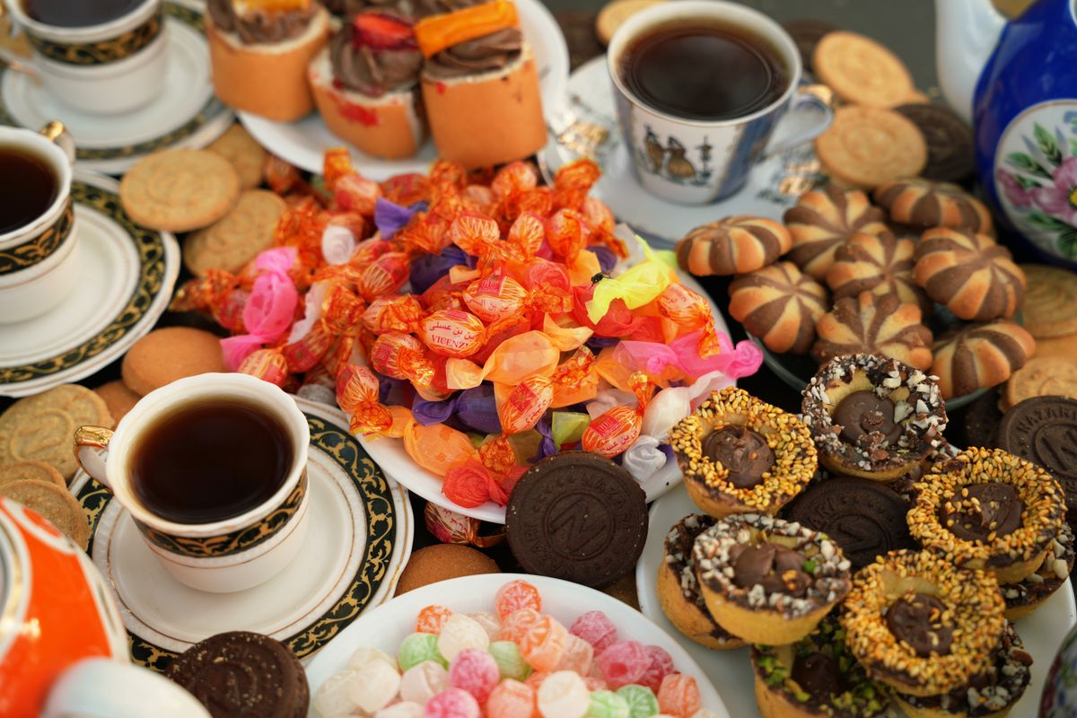 A vibrant spread of Persian sweets and teas showcasing colorful candies, pastries, and ornate cups.