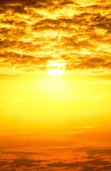 Stunning view of a golden sunrise with dramatic cloud patterns, evoking warmth and serenity.
