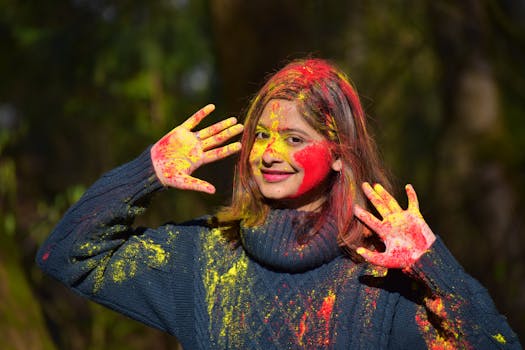 A woman joyfully celebrates Holi with colorful paint on her face, showcasing vibrant cultural expressions.