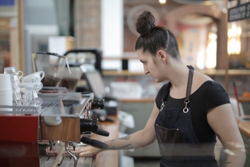 Free A barista expertly makes coffee at a modern café, using an espresso machine. Stock Photo