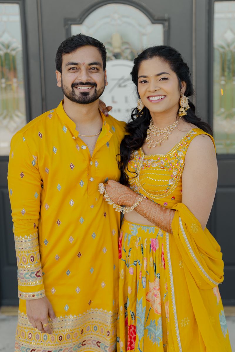 Couple in yellow traditional attire at an Indian pre-wedding ceremony