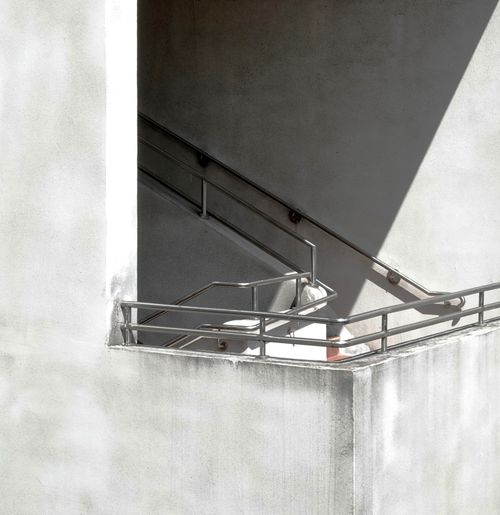 Free Modern concrete staircase with metal railings and strong shadow play. Stock Photo