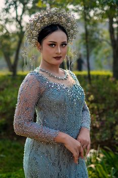 Elegant Sundanese bride in ornate attire posing outdoors in Bandung, Indonesia.