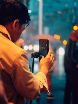 Person capturing city nightlife in rainy Makati, Philippines.