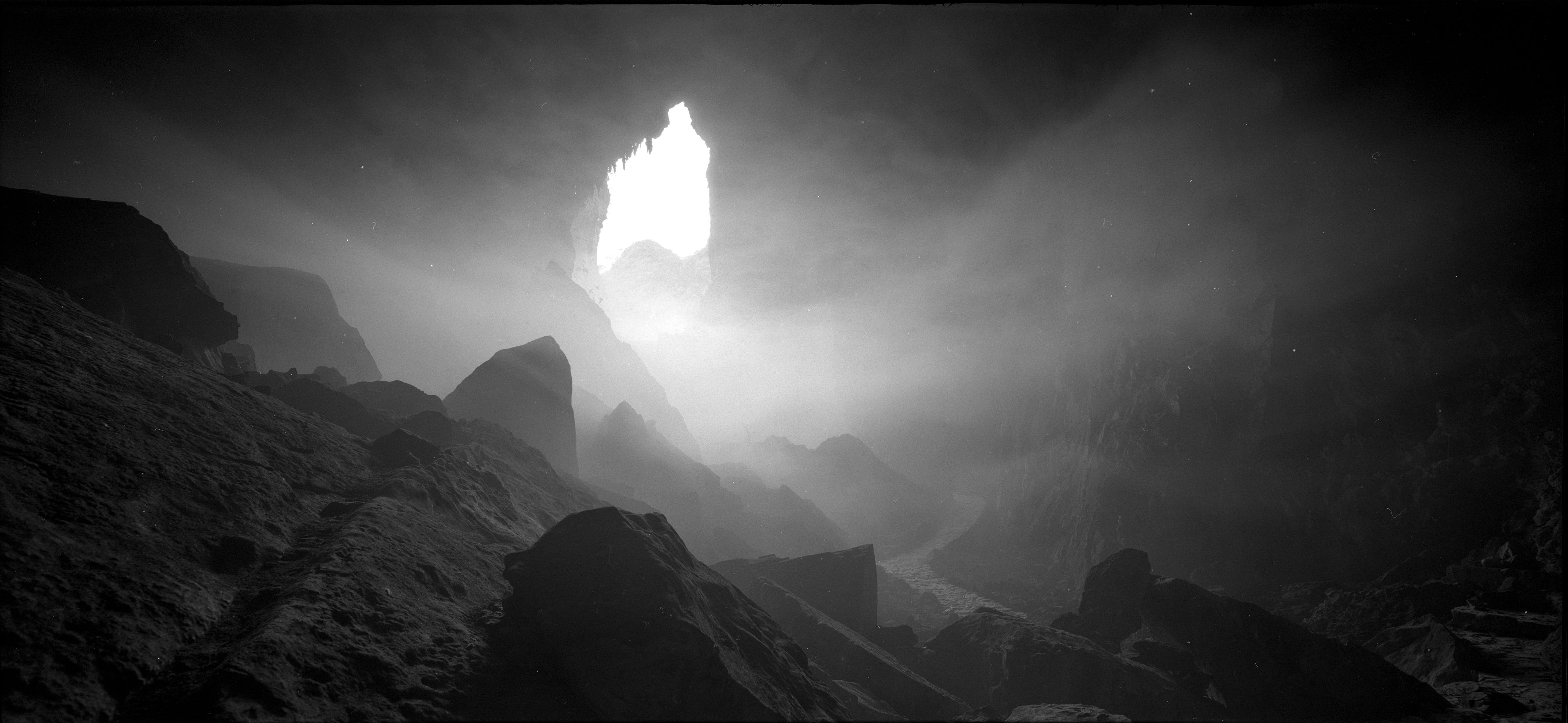 A dramatic view of the rocky interior of a cave in Dong Van, Hà Giang, Vietnam, with light streaming through an opening.