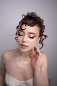 Close-up portrait of an adult woman with vintage hairstyle and makeup, embodying elegance.